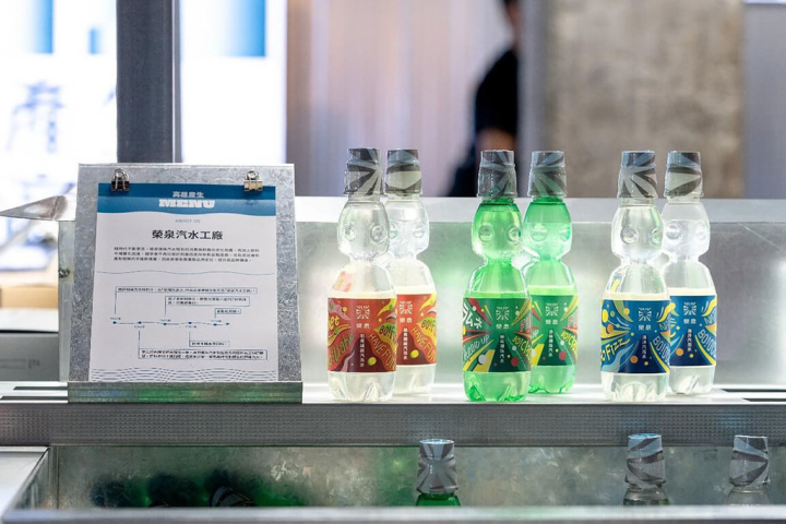 台灣設計展「高雄產生」展區以設計選品概念，集結12家在地企業與隱形冠軍；其中榮泉彈珠汽水以「榮」字出發結合煙火意象，品牌識別活力又清涼。（台灣設計研究院提供）