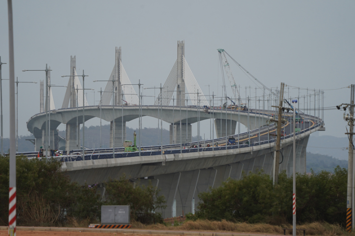 金門大橋包含大、小金端引橋和主橋、邊橋計11座墩柱，共有532支基樁；計劃總經費近新台幣97億元，主橋跨徑200公尺為國內最大跨度脊背橋，工程跨越最深23公尺、潮差6公尺海域。圖為金門湖下端看往金門大橋。