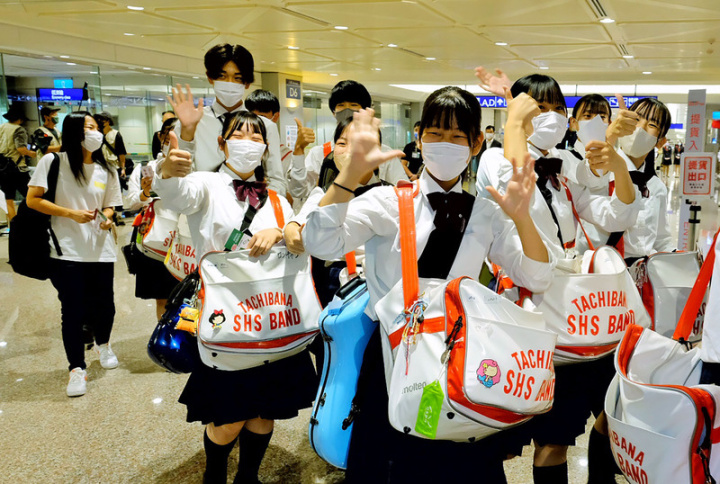 將在今年國慶大典上演出的日本京都橘高校吹奏部師生5日搭機來台，下機後不斷熱情揮手打招呼，更在合照時高喊「台灣讚」，展現青春活力。