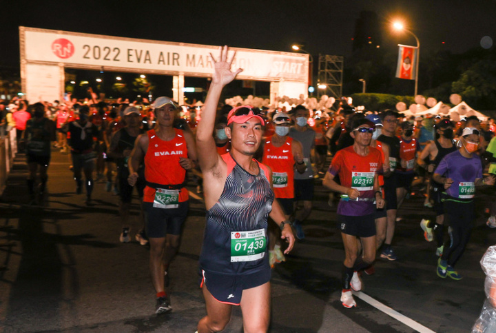 2022長榮航空城市觀光馬拉松23日在總統府前起跑，跑者向媒體揮手致意。