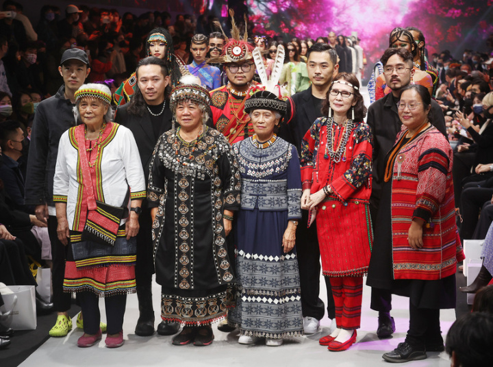 2022台北時裝週SS23「遇見：原住民族人間國寶跨界時尚」開幕秀14日盛大登場，泰雅族藝師尤瑪．達陸（前右起）、賽德克族藝師張鳳英、排灣族藝師許春美與陳利友妹，以及噶瑪蘭族藝師嚴玉英分別和時裝設計師合作，並由模特兒展示跨界成果。