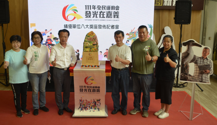 111年全民運動會績優單位獎座7日發布，由在地國家工藝大師謝東哲與陳明洲（右3）共同設計製作，嘉義縣長翁章梁（左3）說，獎座材質運用嘉義縣最著名的交趾陶和阿里山檜木相結合，圖案滿滿嘉義意象。