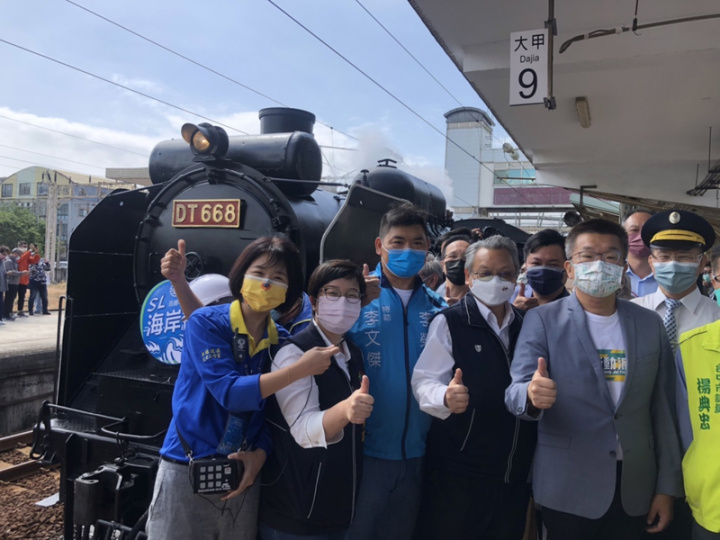 台鐵海線鐵路通車百週年，台鐵局11日出動「蒸汽火車國王」DT668蒸汽火車短暫停靠大甲車站，台中市副市長令狐榮達（前右2）、立法院副院長蔡其昌（前右）與火車合影。