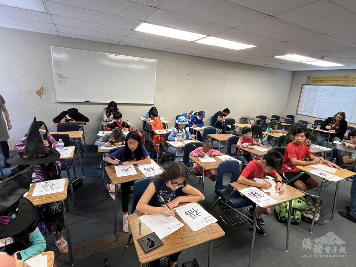 小朋友穿著costume正襟危坐努力用毛筆寫下「春」與「福」。