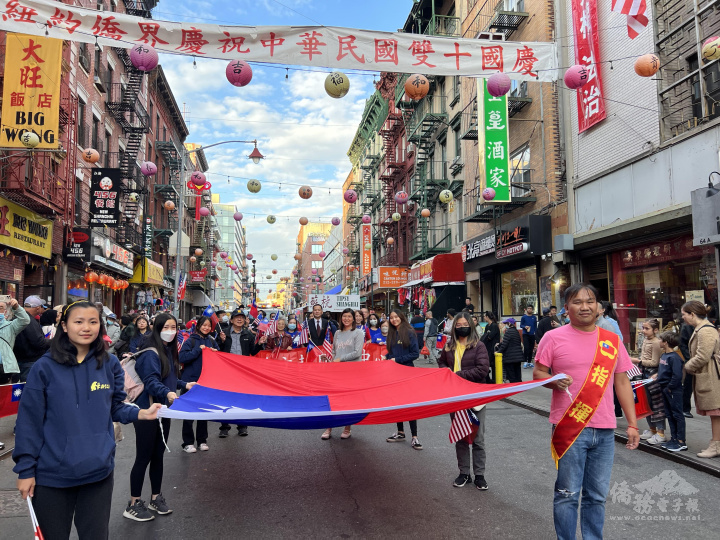 僑務促進委員鄺迺智諮詢導師(右)與FASCA成員手持大國旗入場