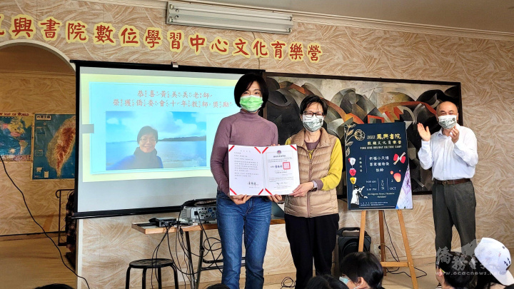 駐奧克蘭辦事處僑務組長邱亞芬（左）頒發黃美美老師（右）十年教師獎勵