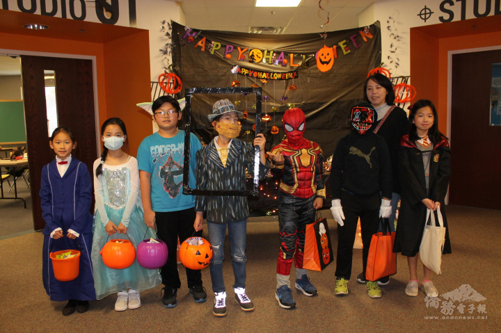 四年級班老師與提著滿桶糖果的學生合影