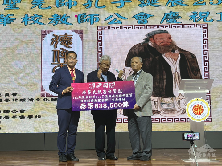 莊仁桂（右）向王紹章（左）提供泰北清萊華校清寒績優學生獎助金