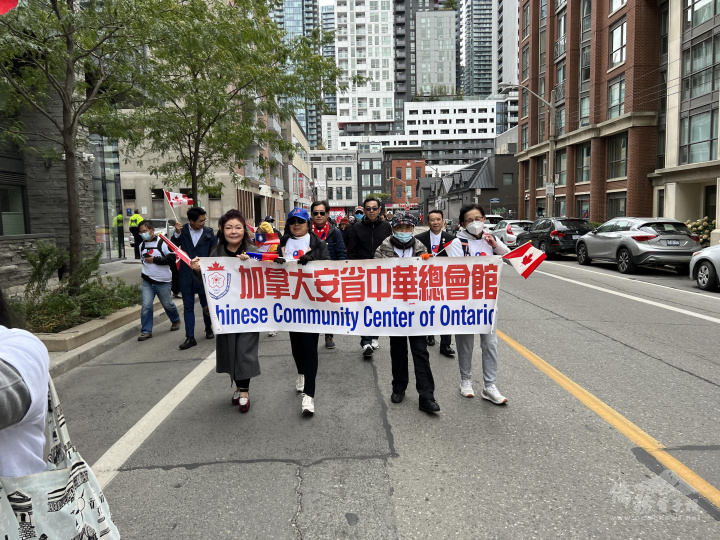 多倫多全僑慶祝雙十國慶遊行隊伍中僑團拉著僑社名稱橫幅遊行祝賀中華民國國慶