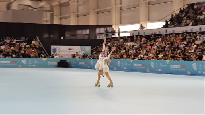 素有花式滑輪甜姐兒之稱的李劭倢（下）與搭檔李劭冠（上），身著客家風格舞衣，在2022阿根廷全項目滑輪世錦賽，凸顯台灣特色，帶給觀眾突破傳統，充滿驚喜的表現。