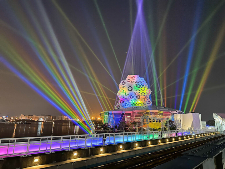 高雄市文化局表示，高雄運用與英國泰晤士河同等級智慧燈光控制系統，串聯高雄流行音樂中心、橋體和河岸燈光連動，並響應高雄同志大遊行，18日起至20日晚間將點上夢幻彩虹色系燈光。（高雄市政府提供）