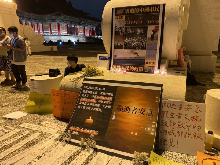 中國多地陸續傳出藉悼念新疆烏魯木齊火災遇難者表達對防疫封控政策的不滿。台北的自由廣場27日晚間也出現聲援活動，現場有鮮花、悼念文與寫有各種支持口號的字條或看板。