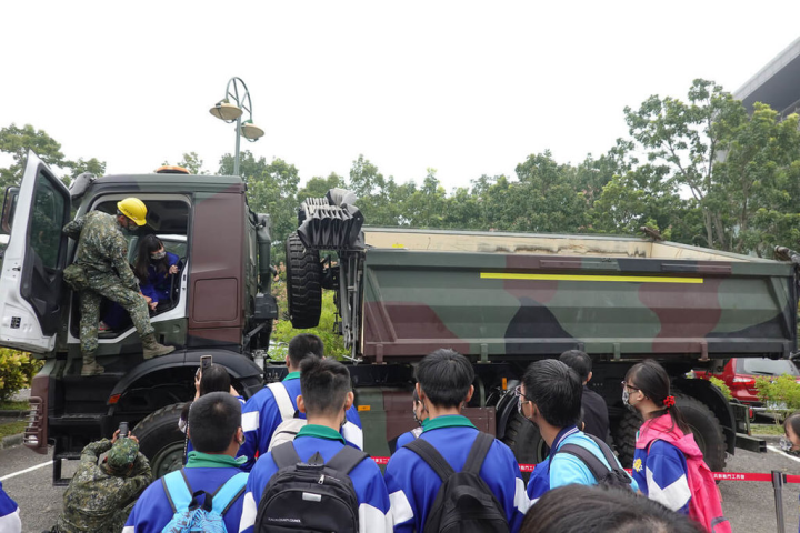 為提升全民國防意識，陸軍第十軍團52工兵群16日開著重機具進入吳鳳科技大學進行宣導，學生們在軍方帶領下爭相體驗傾卸車運作。（吳鳳科大提供）