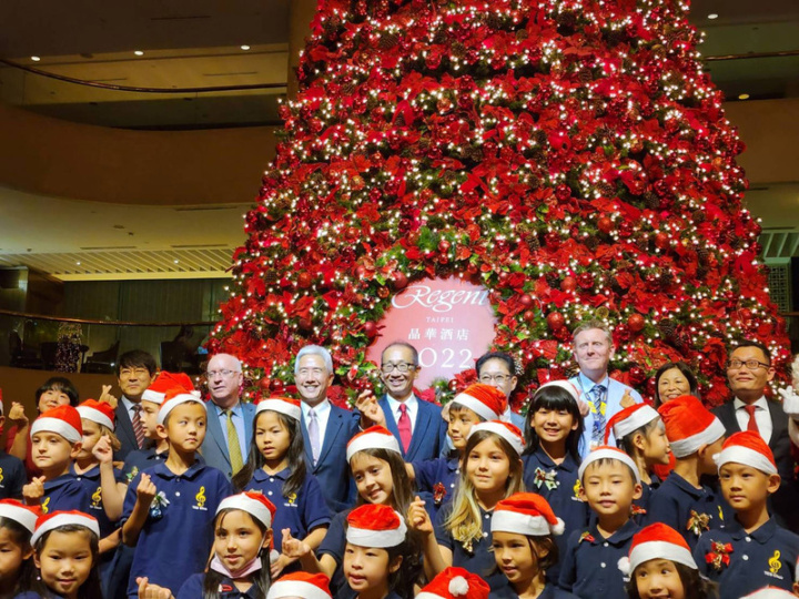 台北晶華酒店24日舉行耶誕點燈儀式，在歐洲學校學生演唱耶誕歌曲聲中，全台五星級飯店室內最高的耶誕樹亮燈。圖右後5為晶華國際酒店集團董事長潘思亮。