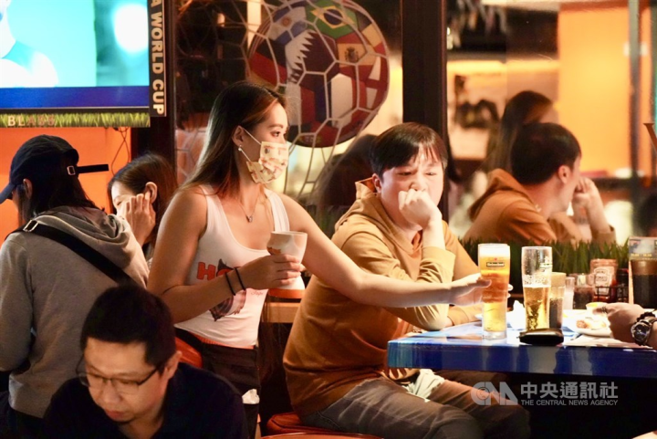 A waitress serves drinks on tap to customers watching the FIFA World Cup at Hooters' Chingcheng store. 