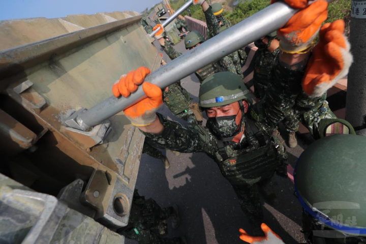 作業官兵配合架橋指揮官的口令，一步步結合橋材。