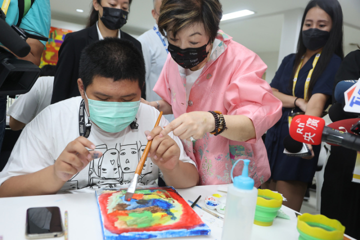 台灣APEC領袖代表張忠謀夫人張淑芬（前右）19日 參訪泰國自閉症基金會，親自指導學童作畫技巧。