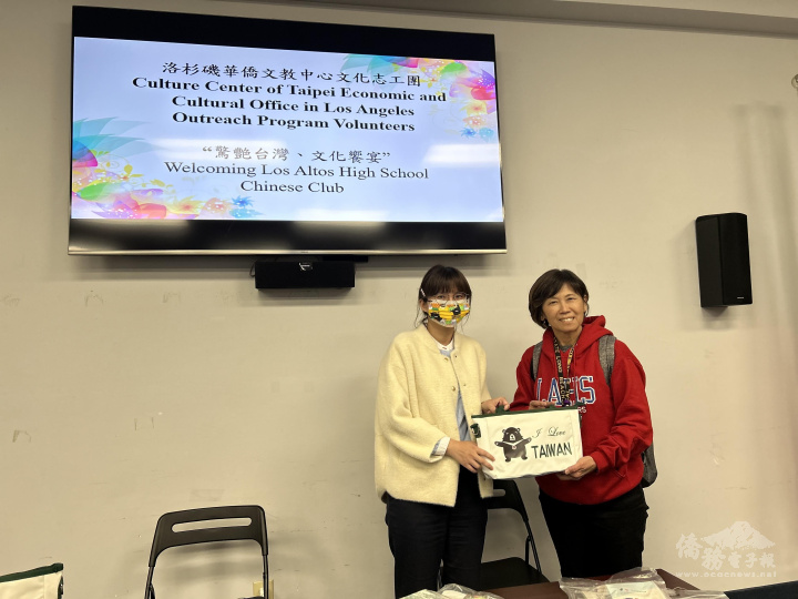 鄭心茹致贈僑委會愛心能量包予該校師生，由白采蓉老師代表接受