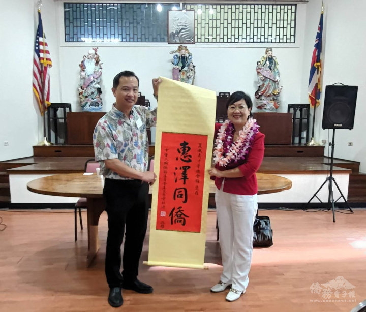 徐佳青(右)代表僑委會致贈「惠澤同僑」掛軸予夏威夷中華總會館主席甘錦雄(左)