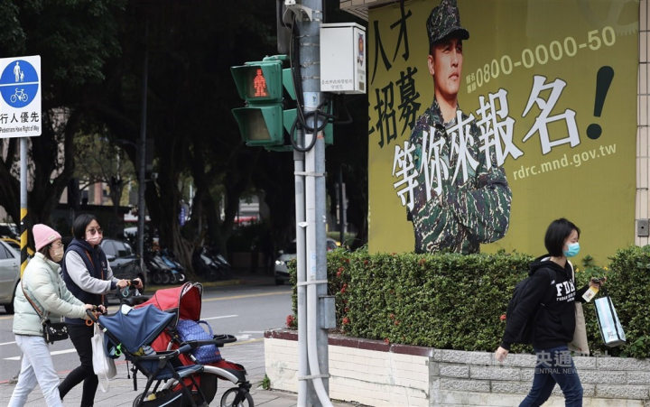 Pedestrians walks past a military recruitment ad in Taipei on Wednesday. CNA photo Dec. 28, 2022