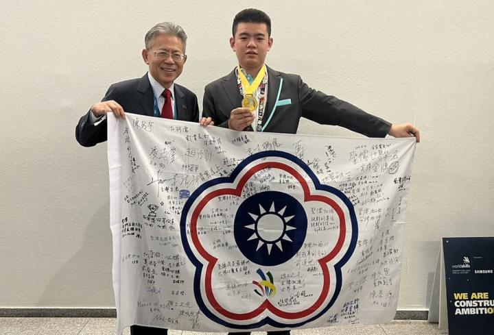 高雄高工電機科校友蕭聖儒（右）代表國家參加2022國際技能競賽奧地利賽場，勇奪「電氣裝配」職類金牌，接受勞動部前次長林三貴（左）表揚。（高雄高工提供）