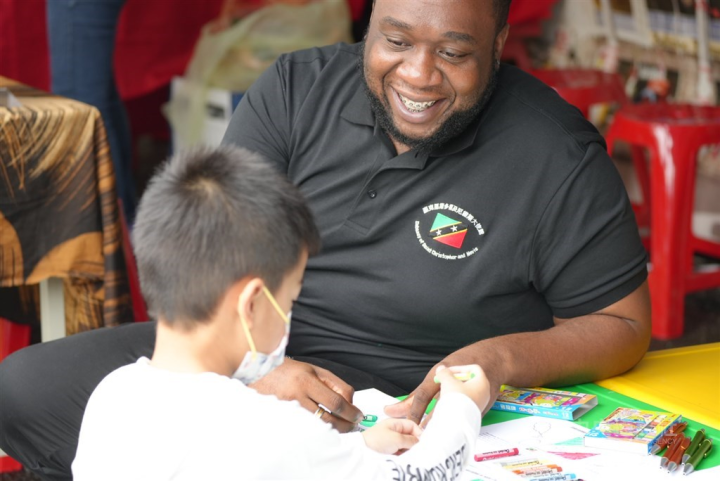 Saint Kitts and Nevis Ambassador to Taiwan Donya Francis interacts with a Taiwanese boy as he colors in at the country's booth at the 2022 Taiwan Reading Festival.