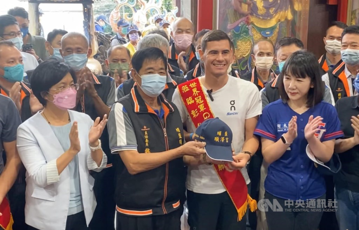 Norwegian ironman Gustav Iden (front row, second right) receives a new baseball cap from the temple in Changhua County during his visit on Sunday. CNA photo Dec. 4, 2022