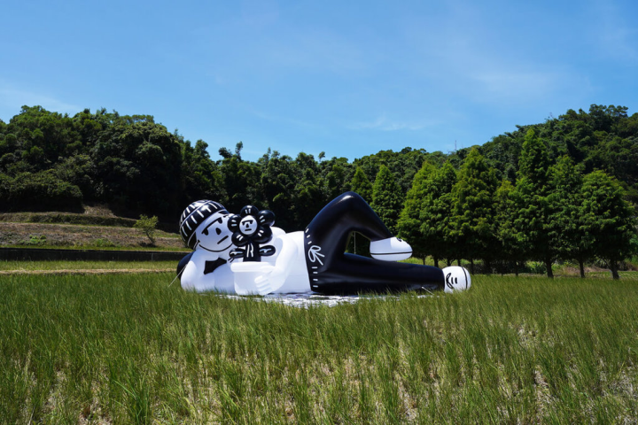 2022亞洲插畫藝術博覽會呈現多元插畫藝術，透過飯店空間讓插畫當主角，例如1樓外與高雄市圖書總館間的草坪可見插畫家Abei（劉正堃）的人偶裝置「放空時光」（Lay Down And Take It Easy）。（亞洲插畫藝術博覽會提供）
