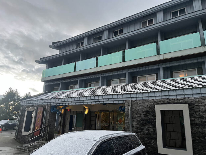 入冬首波寒流發威搭配水氣，合歡山18日凌晨短暫固態降水（霰或雪）約10多分鐘，位於海拔3150公尺的合歡山松雪樓外車輛可見覆蓋薄薄積雪。（南投林區管理處提供）