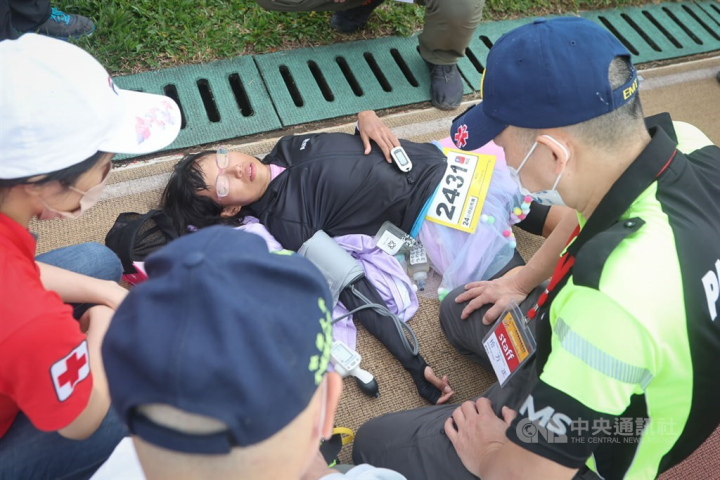 Taiwanese runner Lin Kuan-ju rests on the ground after finishing the 24-hour event. CNA photo Dec. 4, 2022