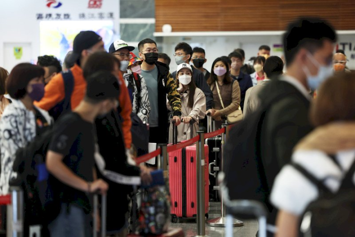 台灣10日起取消入境旅客人數上限，圖為桃園機場，民眾推著行李排隊等候辦理登機手續。