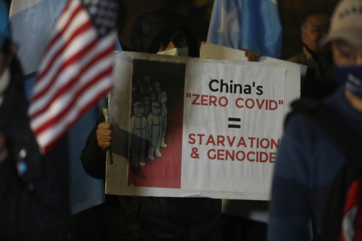 數十名旅美中國人、維吾爾族人11月30日晚間頂著寒風，聚集在中國駐美大使館外聲援「白紙運動」，一名抗議民眾高舉標語，批評中共「清零政策」。