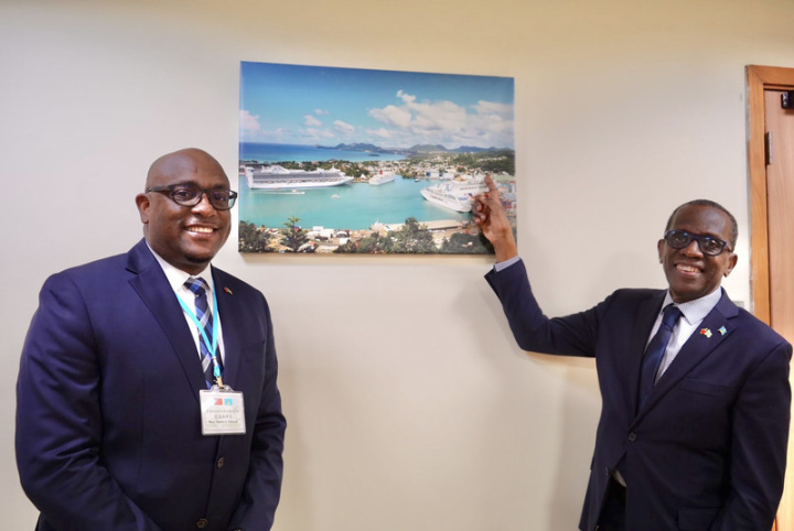 聖露西亞總理皮耶（右）在聖露西亞駐台大使館接受訪問，他指著牆上掛著的照片向記者分享，他的辦公室就在他手指的地方。