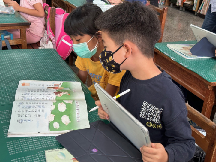 屏東縣潮和國小推動數位學習，低年級學生用iPad拍下課本內容後，須在照片上找出老師指定問題的答案，再上傳資料繳交作業。