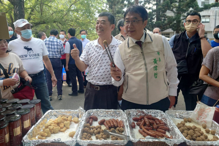 台南市長黃偉哲（前右）4日出席在農委會畜產試驗所及台南農改場舉行的農畜聯合開放日活動，到市集採買並協助行銷農畜產品。