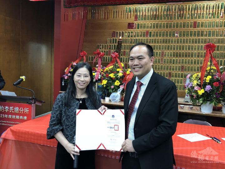 駐紐約辦事處副處長陳珮瑩(左)轉發僑務委員會委員長童振源的賀狀及感謝狀，圖為轉發感謝狀給卸任主席李國威(右)