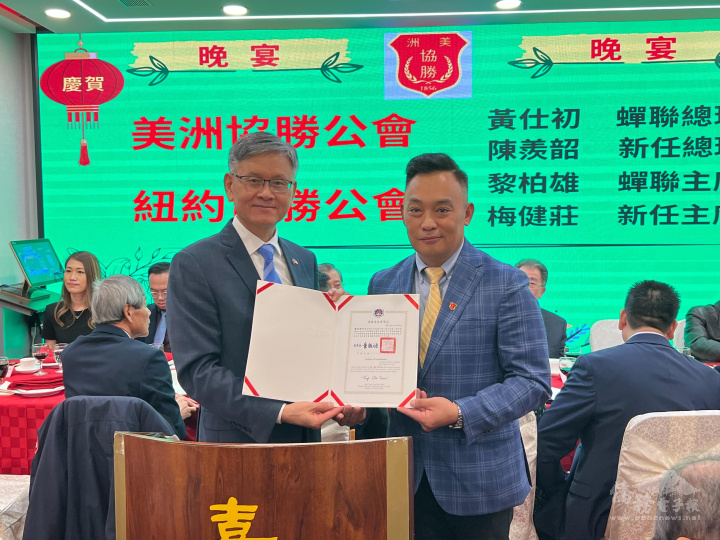 駐紐約辦事處處長李光章(左)轉發僑務委員會委員長童振源賀狀及感謝狀。圖為轉發紐約協勝公會蟬聯主席黎柏雄(右)賀狀