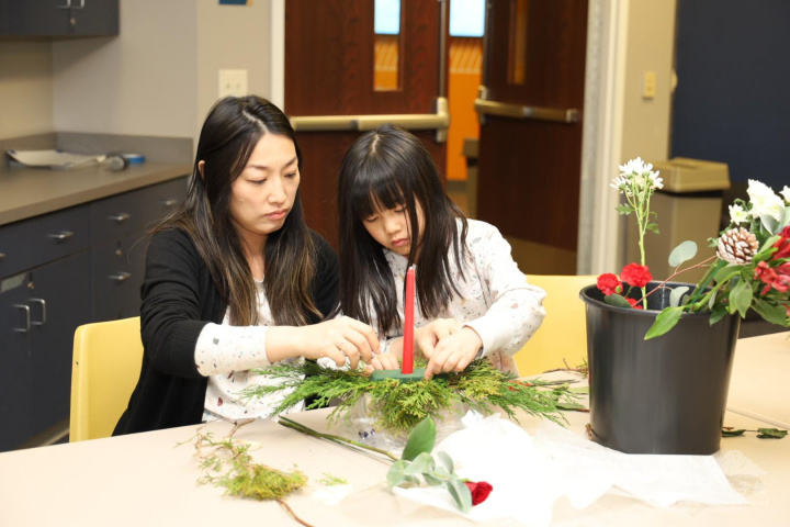 二年級班學生和母親專注調整花材位置，共度高品質的親子時光