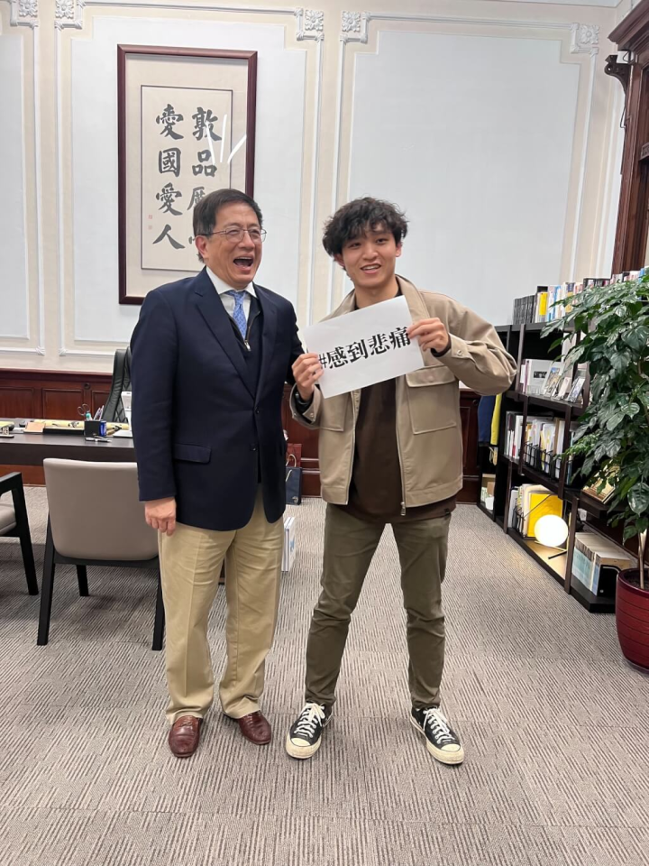 台大校長管中閔（左）在卸任前開放校長室，有學生（右）手持「＃感到悲痛」字卡合影。（圖取自facebook.com/cm.kuan.7）
