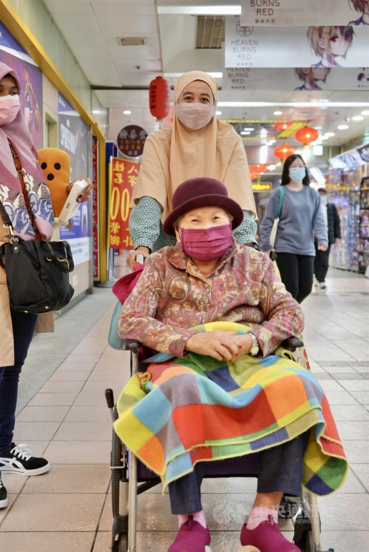 An Indonesian caregiver takes her elderly charge out for a stroll and meal at the underground mall in Taipei Main Station. CNA photo Jan. 23, 2023