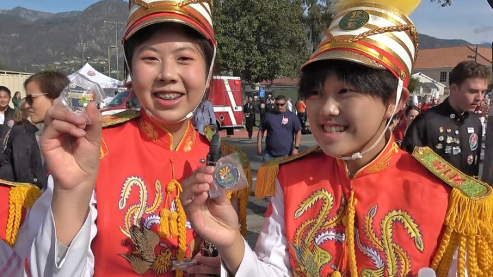 北一女樂儀旗隊2日參加美國玫瑰花車遊行，遊行結束後展露輕鬆的一面，與各國樂隊隊員交換徽章紀念品。