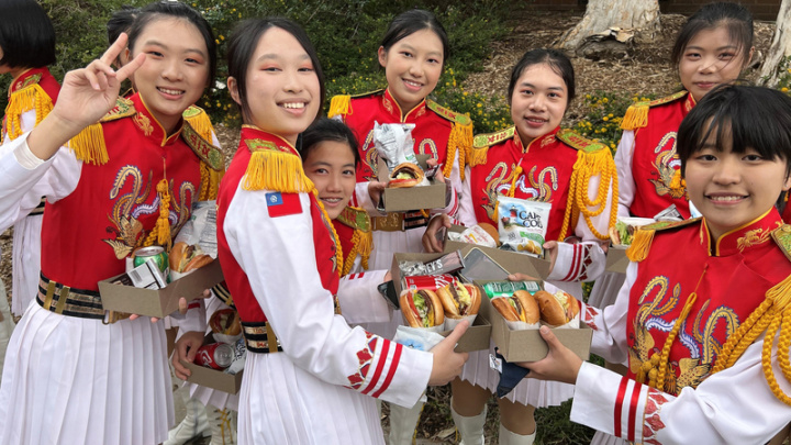 北一女樂儀旗隊2日參加美國玫瑰花車遊行，抵達終點後樂隊隊員享用大會提供的加州名產In-N-Out漢堡。