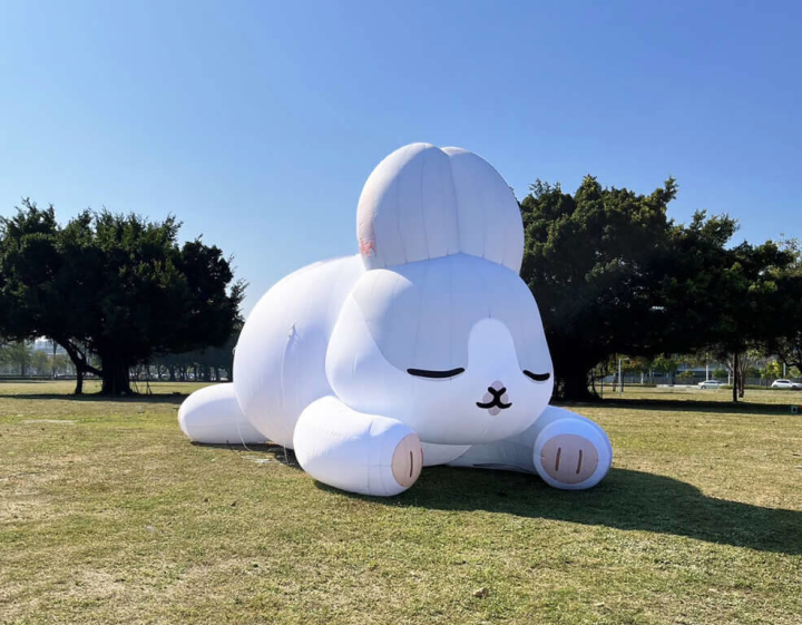 2023高雄燈會在蓮池潭畔舉行，人氣貼圖「ㄇㄚˊ幾兔」以18公尺高巨型充氣裝置，和趴臥草地上可愛造型亮相。（高雄市政府提供）