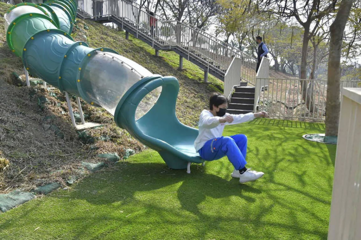 高雄市工務局斥資在小港區大坪頂坪鳳公園打造面積約為0.25公頃的特色遊戲場，以樹屋主題打造遊具，並結合高8公尺、長22公尺全高雄最長的斜坡溜滑梯，讓小朋友在林木之中體驗飛翔騰挪的恣意快感。（高雄市政府提供）