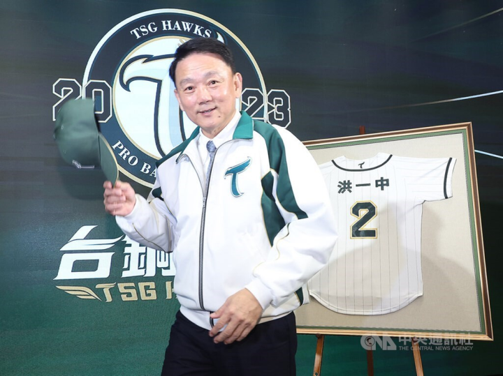 Hong I-chung poses for pictures in front of his TSG Hawks jersey displayed at Monday's press conference in Taipei, where the franchise announces Hong to be the its first manager. CNA photo Jan. 16, 2023