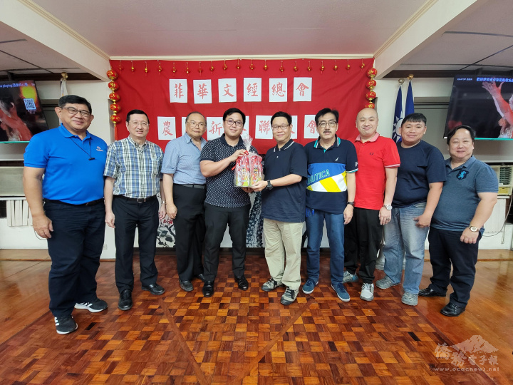 周圩烈（中）及蔡彼得（右1）代表消防研習營同學會贈送小型滅火器予菲華文經總會，由丁俊峰（左4）等人代表接受