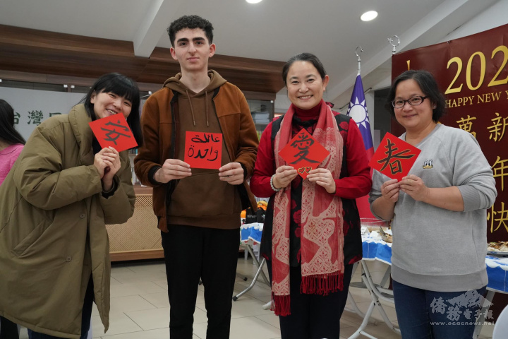 大家一起體驗寫毛筆。(由左至右) 中央社記者鍾侑貞、敘利亞大學生mustafa、僑務顧問周如意、同鄉會會長翁珮菁