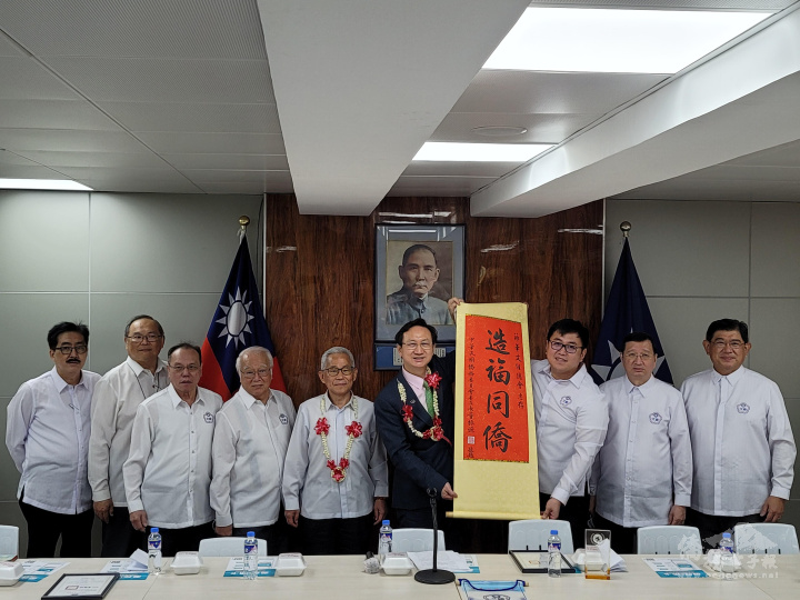 僑委會贈送「造福同僑」卷軸予菲華文經總會，由丁俊峰代表接受
