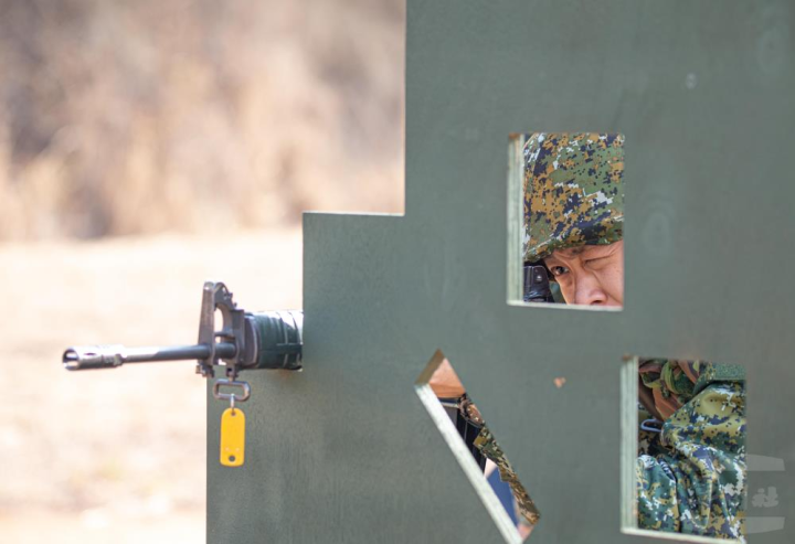 於障礙板後方依序採臥姿、跪姿、立姿三種射擊姿勢實施射擊。