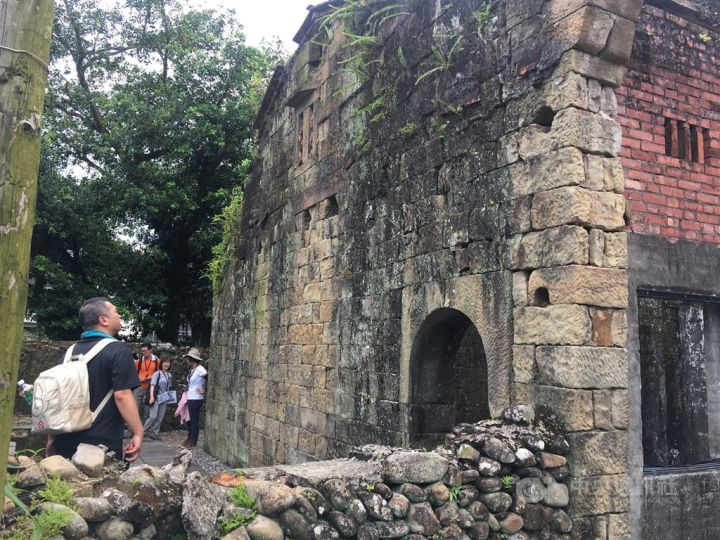 Visitors look at old buildings along the Tamsui-Kavalan Trails. 
